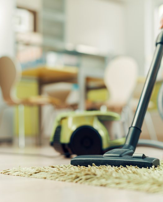 Woman cleaning home with vacuum cleaner.