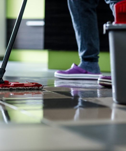 Cleaning with mop. Ceramic floor tiles are wet.