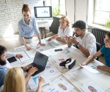 business-technology-and-people-concept-creative-team-or-designers-working-in-office-e1632233122340 business-technology-and-people-concept-creative-team-or-designers-working-in-office-e1632233122340