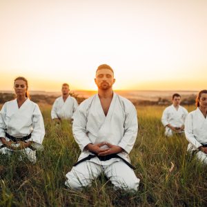 karate-group-sitting-on-the-ground-and-meditates